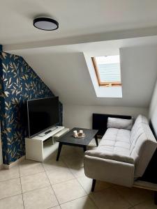 a living room with a couch and a tv at Teplice apartments DELUXE in Teplice
