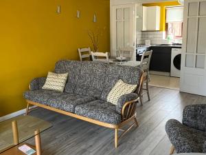 a living room with a couch and a kitchen at Village Retreat in Ely