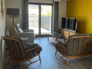 a living room with two chairs and a television at Village Retreat in Ely