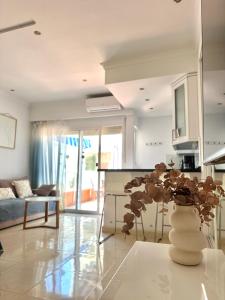 a kitchen and living room with a vase with a plant at Hotel PYR, Spacious Studio with a Big Terrace in Fuengirola