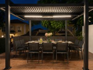 a dining table under a pergola in a backyard at Lux Villa with Year-Round Heated Pool & Game Room in Montequinto +58 photos