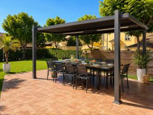 a patio with a table and chairs under a pavilion at Lux Villa with Year-Round Heated Pool & Game Room in Montequinto