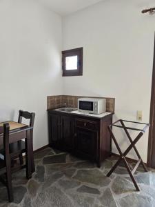 a kitchen with a microwave on a counter with a table at Amalthia hotel in Límni