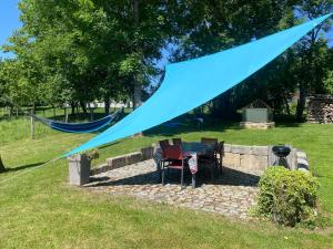 a blue tent with two chairs and a table at Gîte des oursons - Climatisé in Guyans-Durnes