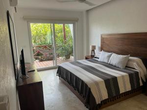 a bedroom with a bed and a sliding glass door at Condo Solana Oceanview and Jungle Bliss! in Sayulita