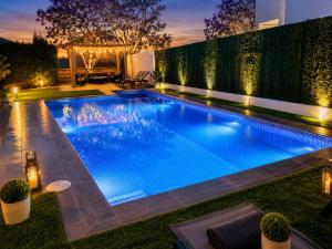 a swimming pool in a backyard at night at Lux Villa with Year-Round Heated Pool & Game Room in Montequinto