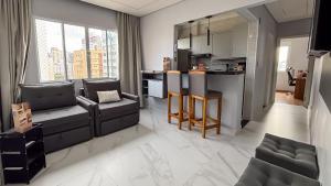a living room with a couch and a kitchen at SHB - Central Miramar Shopping Mall from the beach in Santos