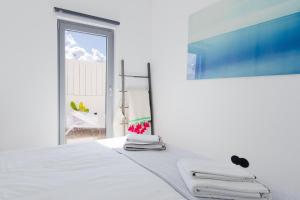 a white room with a bed with a window at Casa Alegra in Carvalhal +31 photos
