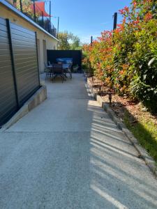 a sidewalk next to a building with a table and chairs at Gîte des oursons - Climatisé in Guyans-Durnes +11 photos