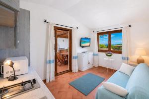 a living room with a blue couch and a tv at Sea View Within Walking Distance of the Beach in Baja Sardinia