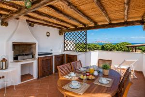 a kitchen and dining room with a table and chairs at Sea View Within Walking Distance of the Beach in Baja Sardinia