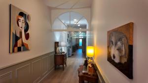 a hallway with paintings on the walls of a house at La Belle Chartreuse in Manciet