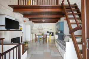 a kitchen and living room with a spiral staircase at Trullimania in Alberobello