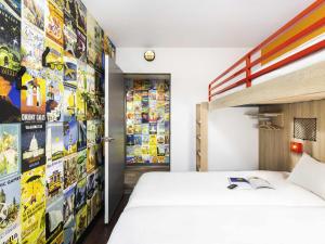 a bedroom with a bed and a wall of stickers at HôtelF1 Angoulême in Champniers