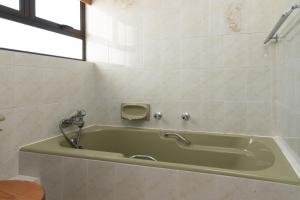 a green bath tub in a bathroom with a window at Chaka Terraces 10 in Ballito +15 photos