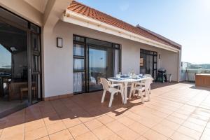 a patio with a table and chairs on a balcony at Chaka Terraces 10 in Ballito