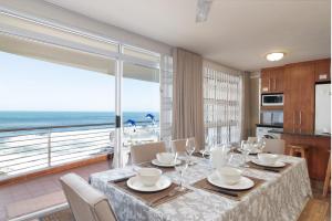 a dining room with a table and a view of the ocean at Chakas Cove 34 in Ballito