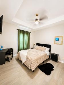 a bedroom with a bed with a ceiling fan and a desk at Gold'n Retreat in Mission