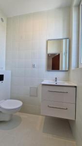 a bathroom with a toilet and a sink and a mirror at Bos-Znam Pokoje in Gdynia