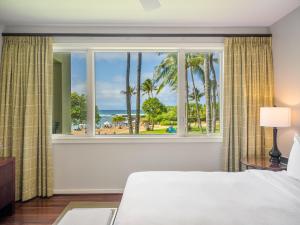 a bedroom with a window with a view of the ocean at 3-Bed Villa 203 at Turtle Bay in Kahuku +43 photos