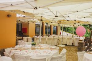a banquet hall with white tables and white chairs at Olvios Hotel in Goura