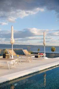 a pool with tables and chairs next to the water at Stella Maris Deluxe in Podstrana
