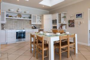 a kitchen with white cabinets and a table and chairs at Colwyn Drive 53 in Sheffield Beach