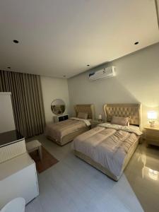 a hotel room with two beds and a mirror at Luna Villa in Al Khobar