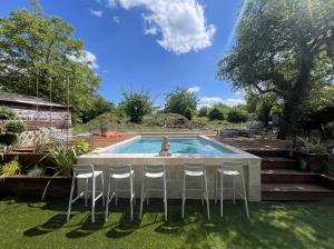 a pool with chairs and a table and a fountain at La grange du Ruet in Saint-Hilaire-Saint-Mesmin
