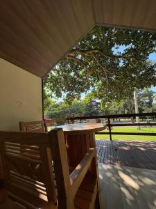 a table and chairs on a deck with a tree at Complexo Turístico Canaã in Nobres