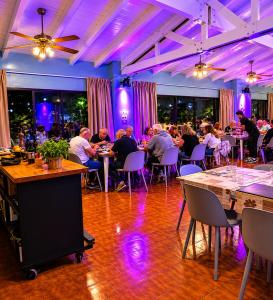 a group of people sitting at tables in a restaurant at Essencial Hotel Spa in Mendoza