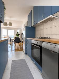 a kitchen with blue cabinets and a dining room at Apartment Iris in Dubrovnik