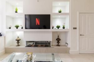 a living room with a tv and a fireplace at Bradford Chic City-Centre Apartment in Bradford