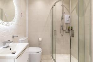 a bathroom with a shower and a toilet and a sink at Bradford Chic City-Centre Apartment in Bradford