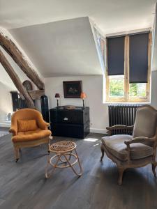 a living room with two chairs and a table at La Vieille Demeure in Barbizon