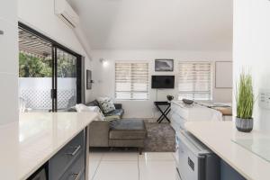 a kitchen and living room with white counters and a couch at La Mer 14 in Ballito