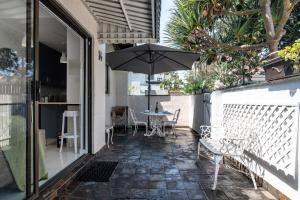 a patio with a table and an umbrella at La Mer 14 in Ballito