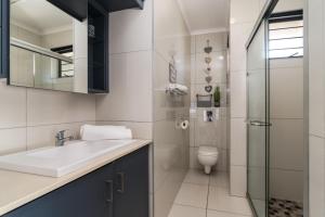 a bathroom with a sink and a toilet at La Mer 14 in Ballito +9 photos