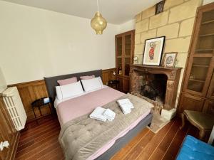 a bedroom with a bed and a fireplace at L'Atelier des Rêves Amboise in Amboise