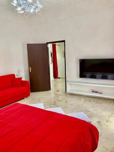 a living room with a red bed and a red couch at Sicilia Benessere in Montedoro