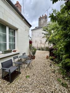 a patio with a table and chairs next to a building at L'Atelier des Rêves Amboise in Amboise