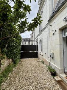 a walkway next to a building with a gate at L'Atelier des Rêves Amboise in Amboise