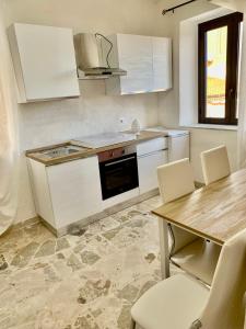 a kitchen with white appliances and a wooden table at Sicilia Benessere in Montedoro