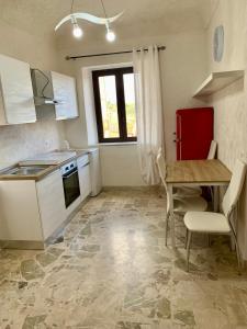 a kitchen with a sink and a table and a refrigerator at Sicilia Benessere in Montedoro
