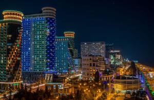 a city lit up at night with tall buildings at Gio apartment in Angisa