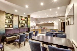 a restaurant with tables and chairs and a bar at Hotel d'Amiens in Paris