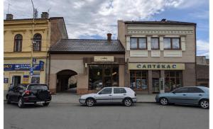 two cars parked in a parking lot in front of a building at EVURI Apartments Petofi in Uzhhorod