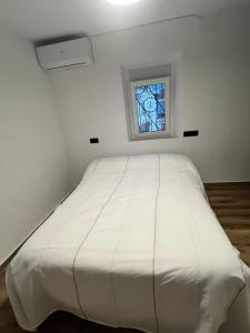 a white bed in a room with a window at Casa Arrabal Villa in Salobreña