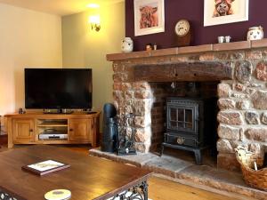 a living room with a stone fireplace and a television at 3 Bed in Appleby-in-westmorland oc-88791 in Crackenthorpe