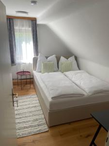 a white couch in a room with a window at Pension Victoria in Millstatt